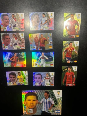 Panini FIFA World Cup spelkort - Samling med Panini FIFA World Cup Brasil 2014 spelkort med holografisk finish. Korten har färgstarka motiv av kända fotbollsspelare, inklusive specialkort som 'Limited Edition'. Perfekt för dig som gillar samlarkort och fotbollsspel. Materialet är glansig kartong. Priserna är satta bara för att säga något, kom med bud. Endast seriösa bud mottages!