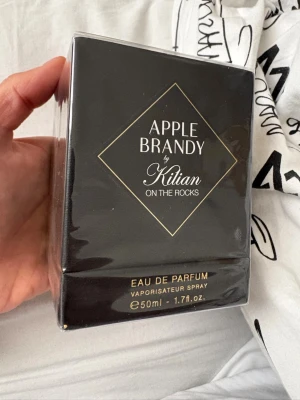 Apple Brandy by Kilian EdP 50ml - Apple Brandy by Kilian On The Rocks är en lyxig Eau de Parfum i elegant svart förpackning med gulddetaljer. Flaskan rymmer 50 ml och doften har inslag av äpple och brandy, vilket ger en unik och sofistikerad karaktär. Perfekt för dig som gillar exklusiva parfymer. Helt ny i förpackning!