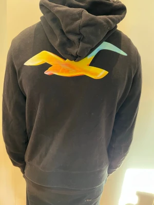Svart hoodie från Hollister - Svart hoodie från Hollister i storlek S modellen är 181 cm och väger 65kg