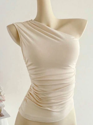 Beige oneshoulder topp - Trendig beige oneshoulder topp med snygg drapering och tight passform. Perfekt för dig som vill ha en stilren och modern look. Tillverkad i mjukt material som sitter skönt mot kroppen.