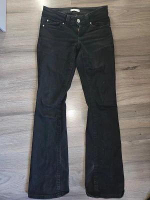 Svarta bootcut jeans från Perfect Jeans - Snygga svarta bootcut jeans från Perfect Jeans med klassisk femficksmodell och knappgylf. Köpta på nelly. Jeansen har en något utsvängd passform nedtill och är tillverkade i ett mjukt denimtyg som sitter skönt. Perfekta för en trendig och avslappnad look. Lite slitna nedtill men annars i fint skick 