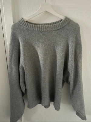 Grå stickad tröja från Nelly - super fin grå stickad tröja med lite vidare ärmar från nelly! fint skick, använd och lite nopprig skriv för bilder på pris kan diskuteras  storlek s