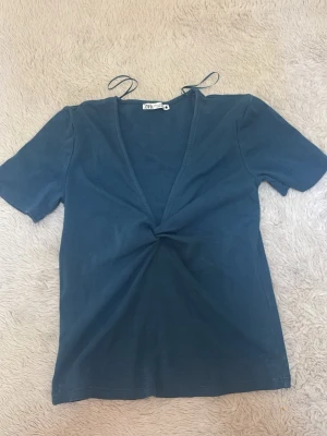 Blå v-ringad topp från Zara - Säljer en blå topp från Zara med v-ringning och en twistad detalj framtill 🩵