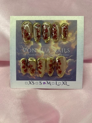CherryMelt (M);Medium Almond - Unika handgjorda press-on naglar i en medium lång mandelform. Designen har en nude cateye bas med röda cateye blommor och handmålade detaljer i guld. Perfekta för dig som vill ha något extra och konstnärligt på naglarna. M: 16 mm, 12 mm, 12,5 mm, 11,5 mm, 10 mm