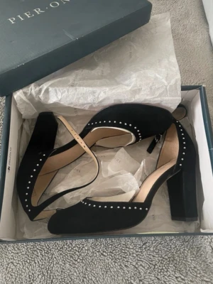 Klackar - Eleganta svarta klackar från Pier One med fina nitar som ger en stilren men feminin look ✨ Endast provade inomhus, i mycket fint skick. Perfekta till fest, middag eller andra tillfällen när du vill känna dig extra fin 🖤  ✔️ Säljs i originalkartong ✔️ Bekväm klack ✔️ Lätta att matcha  Skicka gärna ett meddelande vid frågor eller intresse 💌  ⸻  	•	Klackar 	•	Pumps 	•	Festskor 	•	Svarta skor 	•	Pier One 	•	Dam