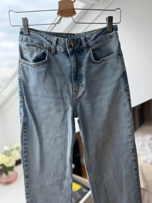 Ljusblå raka jeans från Bik Bok - Säljer ett par ljusblå jeans från Bik Bok med rak passform och hög midja. Klassisk femficksmodell med knapp- och dragkedjegylf. Jeansen är tillverkade i denim med en snygg tvättad look. Köpt för 699kr. Frakt tillkommer. Längd 32 storlek 24