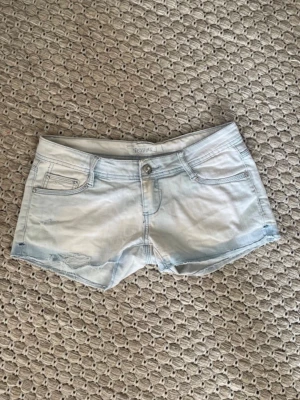 Lågmidjade jeansshorts - Super snygga Lågmidjade ljusblåa jeanshorts med slita detaljer fram till.🩷