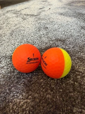 Srixon golfbollar orange/gul - Två golfbollar från Srixon, modell Q-STAR TOUR. Ena bollen är helorange och den andra är delad i orange och gul. Tillverkade i slitstarkt material med klassisk dimple-yta för bättre flyg. Perfekt för dig som vill sticka ut på golfbanan. Skriv privat för pris 