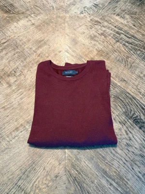 Merinoull tröja från Riley - Snygg vinröd stickad tröja från Riley i mjuk merinoull. Den ät i storlek S och är lite använd. Säljer då den är nu förliten. Köptes i butik för 899kr.