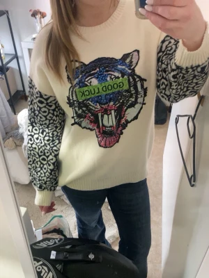 Vit stickad tröja med tiger  - Cool stickad tröja i vitt med stora svarta leopardmönstrade ärmar. Den är aldrig använd och köptes i Portugal för ca 700kr. Står ej storlek men jag har s/m för referens. Öppen för prisförslag!💕