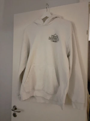 Vit hoodie Peanuts Racquet Club - Snygg vit hoodie från H&M. Peanuts Racquet Club med tryck på bröstet. Klassisk känguruficka framtill och huva med dragsko. Mjuk bomullskänsla och avslappnad passform, perfekt för en chill look.