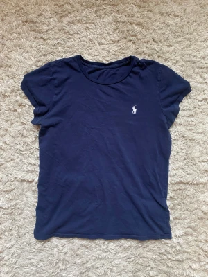 Mörkblå t-shirt från Ralph Lauren - Finns ett hål på tröjans framsida men det är inget man märker av. Tveksam på äktheten.