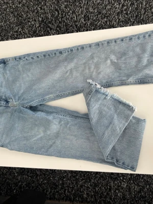 Ljusblå bootcut jeans från Gina perfect jeans - Ljusblå bootcut jeans från Ginaperfect jeans med råa, fransiga benslut. Klassisk femficksmodell i denim med hög midja och breda ben. Perfekta för en avslappnad och trendig look.