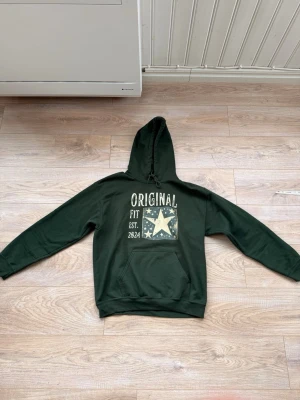 Original Hoodie - Mörkgrön hoodie med ”Original tryck och en stjärna på framsidan. Nästan helt ny. Storlek M.