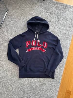 Marinblå Ralph Lauren Hoodie - Finns 2 defekter som syns på bilderna men i övrigt bra skick. Skickar fort