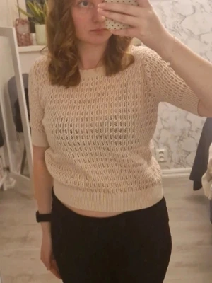 Beige stickad topp från H&M - Snygg beige stickad topp från Lager157 med korta ärmar. Tröjan har ett luftigt hålmönster och ribbade muddar vid ärmslut och nederkant. Skriv vid intresse ❤️