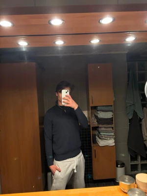 Mörkblå halvzip från Jack & Jones - Snygg mörkblå tröja från Jack & Jones med halv dragkedja och hög krage. Tillverkad i mjukt material och har lång ärm. Perfekt för en clean och stilren look.