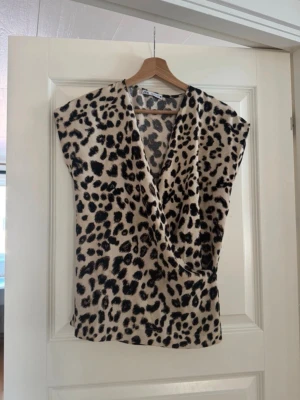 Leopard topp från Zara - Superfin omlott topp från Zara i leopard print. Perfekt till en fest eller middag! Använd 1-2 gånger, toppen är i nyskick. Storlek S 🐆