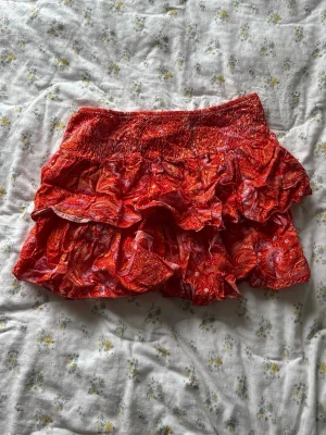 Minikjol  - Så fin minikjol i orange/korall/rött mönster 