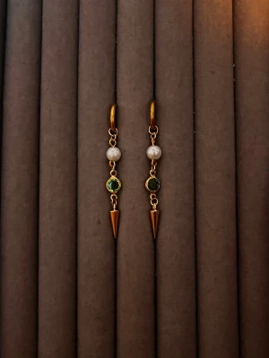 Guldpläterade örhängen med pärlor - Snygga guldpläterade örhängen med vita pärlor och gröna stenar. Hängande design med spetsiga konformade detaljer längst ner. Perfekt för dig som gillar unika och trendiga accessoarer med lite edge.