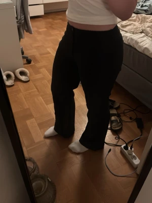 Svarta raka jeans - Lågmidjade svarta kostymbyxor med lös passform. Vet inte ifrån vart. Bra i längd till 156-158