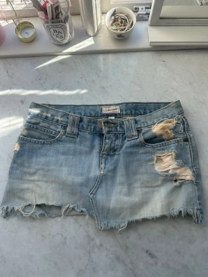 Vintage Abercrombie & Fitch jeanskjol - Såå snygg lågmidjad jeanskjol från abercrombie & fitch med slitningar i storlek 0💕 Midjemått:36 cm Längd fram cirka: 24 cm Längd bak: 28 cm