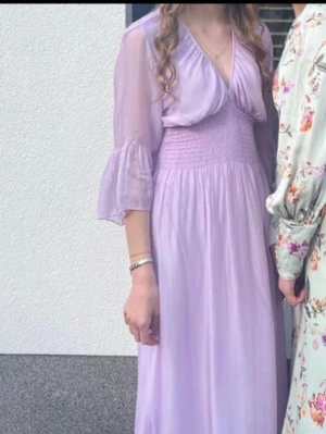 Balklänning studenten prom dress - Säljes klänning i 100% äkta siden, tillverkad i Italien. Underbar i pastell-lila färg. Passar utmärkt som balklänning eller bara för sommarens fester. Klänningen är hel längd. Klänningen har ett tunt foder i viskos/elastan, så den är inte genomskinlig. Klänningen har använts två gånger på fester. Det finns inga tecken på användning förutom en mycket liten reva (se bilder) men den syns knappt vid användning. Klänningen har ingen storlekslapp men på bilderna syns den