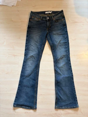 Blå bootcut jeans  - Säljer ett par klassiska blå bootcut jeans . Perfekta för dig som gillar retrostil och vill ha ett par jeans med cool siluett.