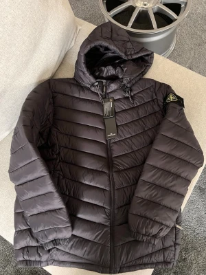 Mörkgrå jacka ifrån Stone island - En sprillans ny jacka ifrån stone island i nytt skick utan defekter jackan är i small men funkar om man är xs. Skriv om du undrar något 