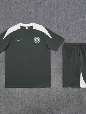 Chelsea Nike fotbollsträningsset  - Chelsea FC träningsset från Nike i svart med vita detaljer. Setet består av en t-shirt med klubbmärke och Nike-logga på bröstet samt matchande shorts med elastisk midja och vit panel. Perfekt för fotbollsträning eller sportig stil.