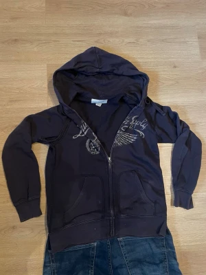 Denim & supply zip - Snygg mörkblå Hoddie med dragkedja från Denim & Supply Ralph Lauren. Hoodien har tryck med en vinge och text på bröstet, två fickor fram och en stor huva. Perfekt för en avslappnad och cool stil.                                                                                 Pris kan diskuteras vid snabb affär 