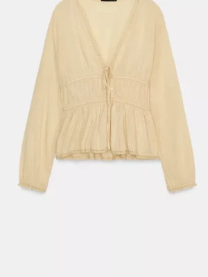  blus med knytning och volang - Söt beige/ljusgul blus med v-ringning, knytning framtill och volang nedtill. Lätt och luftig modell med långa ärmar och diskreta spetsdetaljer längs kanterna. Säljer pga att den ej används. 