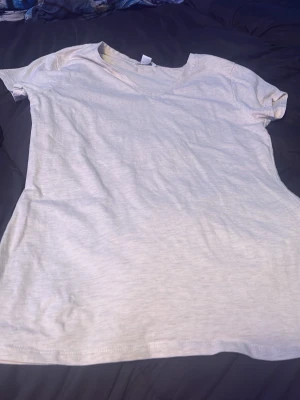 Vit basic t-shirt från AMISU - Enkel och stilren vit t-shirt från AMISU i mjuk bomull. T-shirten har korta ärmar och rund halsringning, perfekt för en clean och avslappnad look. Passar till allt och är ett måste i garderoben.