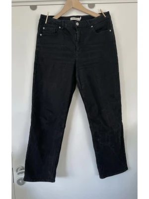 Carin Wester - svarta jeans - storlek 42 - Stilrena svarta jeans från Carin Wester i storlek 42. Klassisk design med fem fickor, hällor för bälte och knappgylf. Stabil denim i 100% bomull, så bra material som andas. Tidlös modell som passar till allt. Mycket gott skick!
