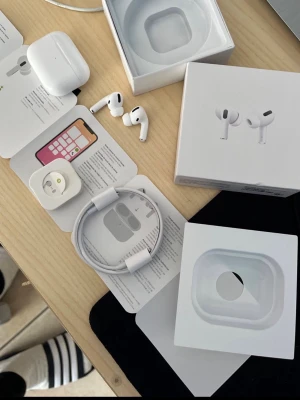 Apple AirPods Pro trådlösa hörlurar - Säljer ett par Apple AirPods Pro med laddningsetui och USB-C laddkabel. Hörlurarna är vita, har in-ear design och levereras i originalförpackning. De är tillverkade i plast och silikon och har en stilren, minimalistisk look med touchkontroller på sidorna.    Btw microdonen kvalitet är lite sådär, men ljudet är perfekt