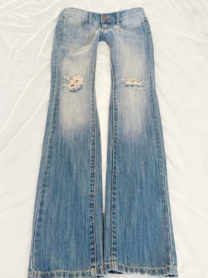 Ljusblå vintage superlågmidjade jeans med slitningar - Så snygga ljusblå superlowwaist jeans med slitna detaljer och hål! ❤️ midjemått 38 cm Innebenslängd: 86 cm ❤️