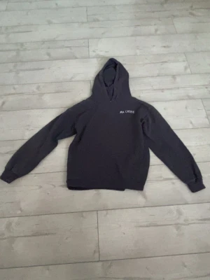 Marinblå hoodie med tryckt Ma Chérie  - Cool svart hoodie med huva och glittertryck på både bröstet och ryggen. På ryggen står det 'Ma Chérie' med två hjärtan i vit. Perfekt för dig som vill ha en unik och trendig look. Materialet känns mjukt och bekvämt.