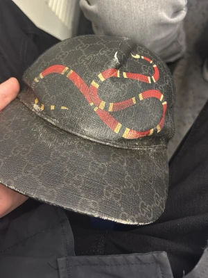 Gucci keps med orm och GG-mönster - Säljer en svart Gucci keps med det klassiska GG-monogrammet tar byte kepsen är äkta!