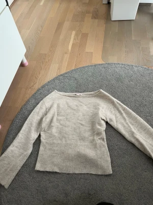 Beige stickad tröja Gina Tricot - Beige stickad tröja från Gina Tricot med bred ribbad kant nedtill och långa ärmar. Tröjan har en enkel, rak passform och är tillverkad i mjukt material som passar perfekt till alla tillfällen.💕