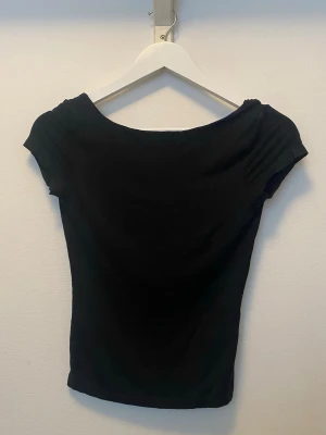 🖤 Svart topp med öppen rygg - ✨ Snygg svart croppad topp med korta ärmar och en öppen rygg, söker nytt hem. Skön i materialet och i fint skick. Inköpt på Gina Tricot. Storlek XS. ✨✨