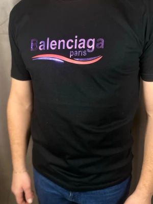 Svart  Paris t-shirt - Snygg svart t-shirt  med glansigt lila tryck och texten 'Balen' på bröstet. T-shirten har korta ärmar och en klassisk passform. Perfekt för dig som vill ha en stilren och trendig look.