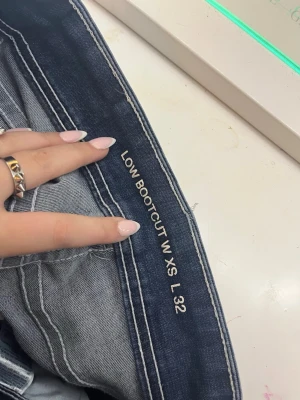 Bootcut jeans lowwaist - Mörkblå bootcut jeans med låg midja och klassisk femficksmodell. Jeansen har en snygg tvätt och utsvängda ben, vilket ger en retro och trendig vibe. Perfekta för dig som gillar en avslappnad men ändå stilsäker look.               Pris kan diskuteras vid snabb affär💗