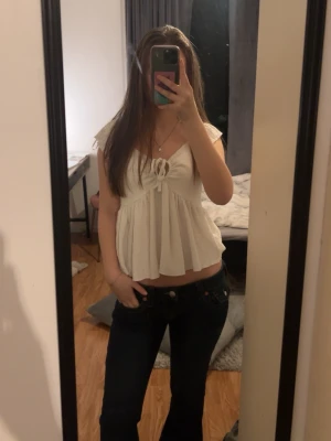 Vit topp med knytning fram - Söt vit topp med korta ärmar och knytning framtill. 