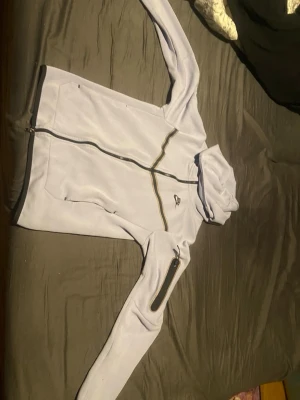 Ljuslila hoodie från Nike Tech - Snygg ljuslila hoodie Nike Tech i storlek XS. Hoodien har hel dragkedja framtill, fickor på sidorna och en extra ficka med dragkedja på ena ärmen. Klassisk huva och sportig design, perfekt för en avslappnad stil. Inte mycket använd.  Se bilder för skick, be om fler bilder om du vill och ⭐️priset går alltid att diskutera 
