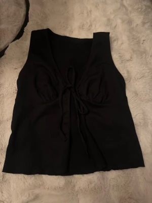 Svart croppad linnetopp med knyt -  svart croppad linnetopp med djup v-ringning och knyt framtill. 