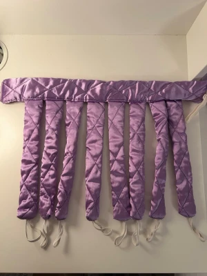 Lila heatless curls set i satin från Normal - Ett lila heatless curls i satin från Normal. Den har quiltad yta och elastiska snoddar i ändarna för enkel användning. Perfekt för att skapa lockar utan värmeverktyg. 