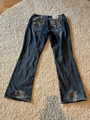 Miss me jeans - Miss Me jeans storlek 33 (easy boot)  Midjemått: 45 cm Midjehöjd: 23 cm Innerbenslängd: 81 Totalt längd: 106 cm Benöppningen: 27 cm  Defekt längst ner (slitning) se bild.    