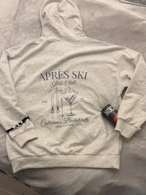 Après Ski hoodie  - Stilren grå aprés ski hoodie som passar bra till det mesta. Tunt och skönt bomulls material. Perfekt detalj till en fet outfit. Helt ny och vi skickar inom någon dag från att du har beställt.                        ‼️Glöm även inte att köpa våra armband som syns på första bilden‼️