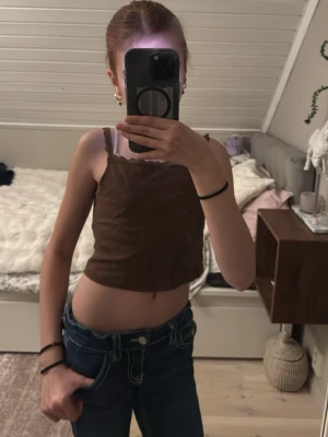 Kort brunt linne🤎 - Detta fina linne är också ”magtröja”. Jag gillar inte det så mycket, därför jag säljer den!!❤️‍🔥🤎 spets upptill och har ribbade ränder över hela linnet