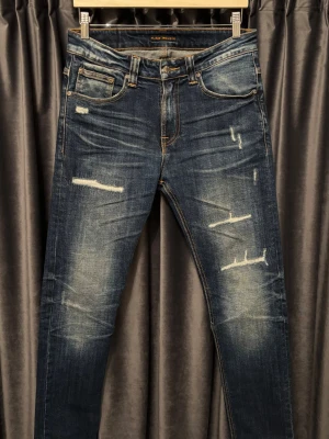 Nudie jeans - SLITNINGAR - Nudie jeans - skick 9/10, mycket fint skick! - modell: Thin Finn - storlek 30/32, passar slim fit, men kan även sitta mer straight om man vanligtvis har en mindre midjestorlek - utan tvekan, de FETASTE nudie jeansen jag skådat! - hör av er vid frågor🙌🤩